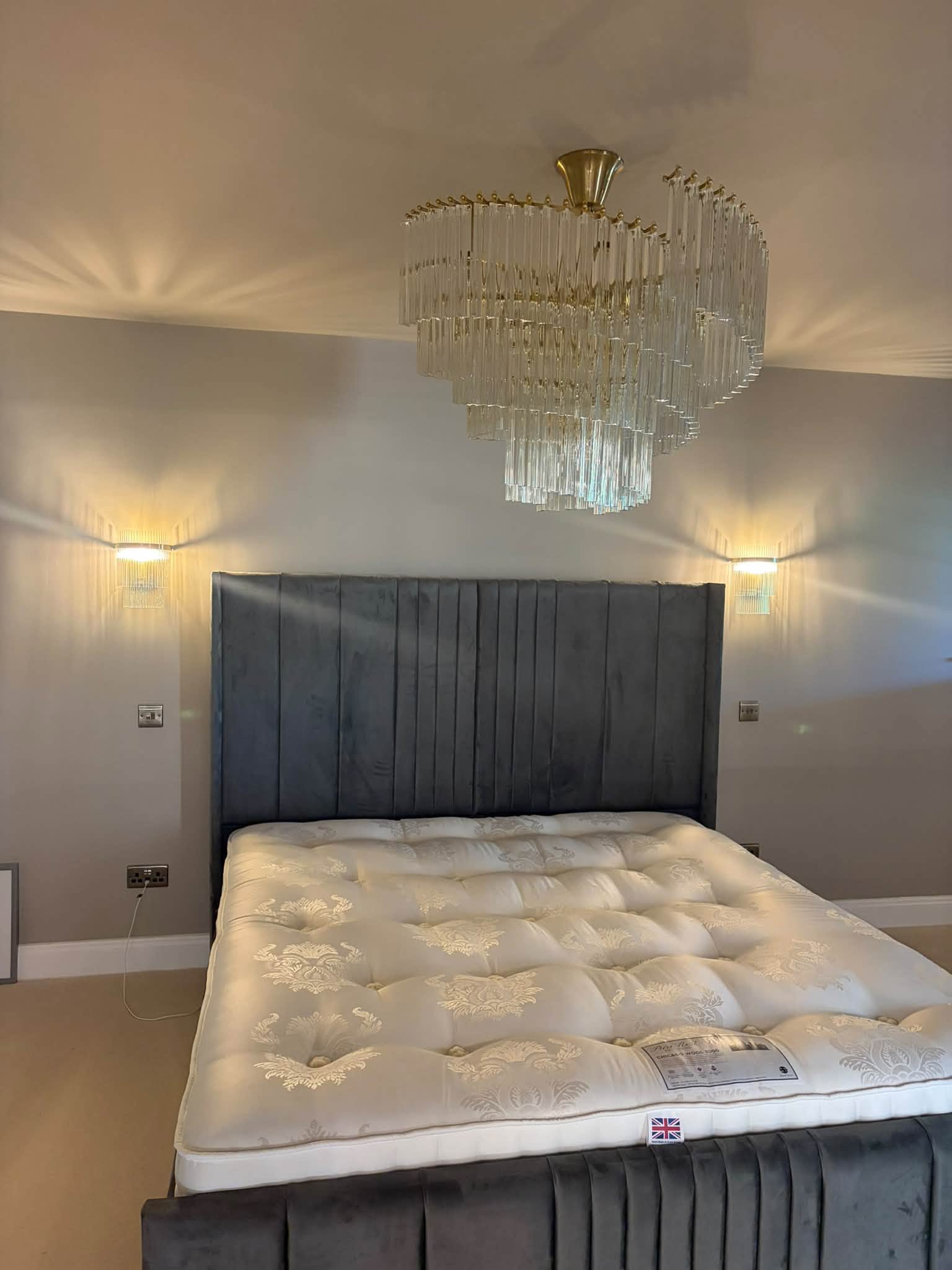 Finished bedroom lighting, with a chandelier and wall lights